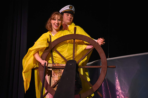 woman and man on stage yellow raincoats